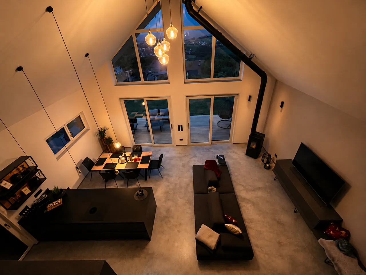 Offener Wohnbereich im Chalet Panorama mit hoher Decke und Fensterfront
